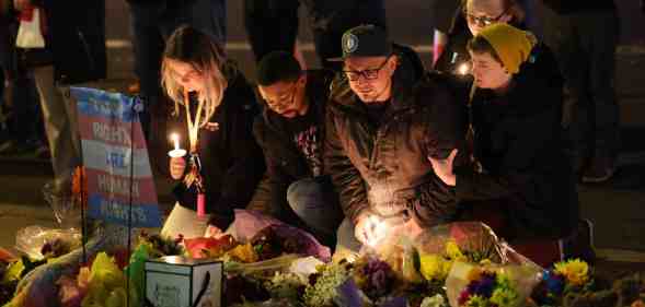 A group of people, some with candles, hold a vigil at a makeshift memorial near the Club Q nightclub on 20 November 2022 in Colorado Springs after a deadly mass shooting