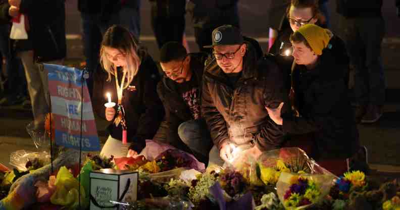 A group of people, some with candles, hold a vigil at a makeshift memorial near the Club Q nightclub on 20 November 2022 in Colorado Springs after a deadly mass shooting