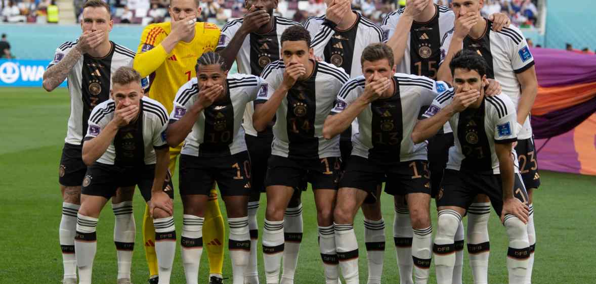 German football team members pose with their hands covering their mouths as they line up for the team photo ahead of the FIFA World Cup Qatar match between Germany and Japan