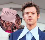 Harry Styles in a suit with a giant shirt collar, and a fan holding up a 'Daddy?' sign