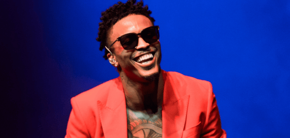Singer August Alsina performs at the 02 in London wearing a red blazer and black sunglasses