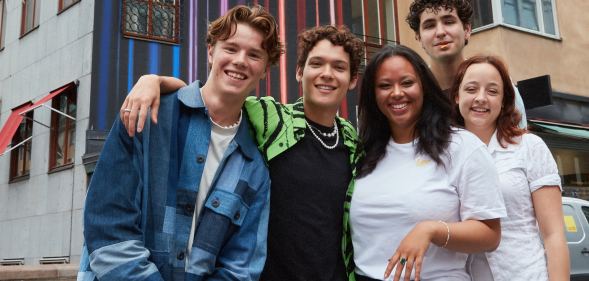 Actors from Netflix series Young Royals in a group publicity shot taken in front of some buildings. (Netflix)