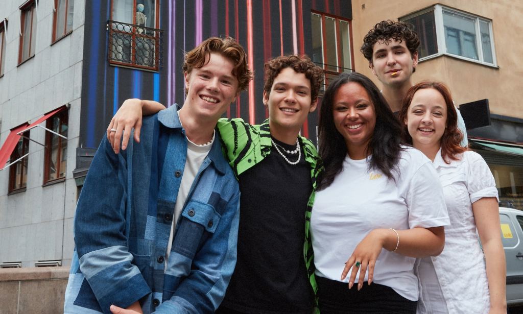 Actors from Netflix series Young Royals in a group publicity shot taken in front of some buildings. (Netflix)