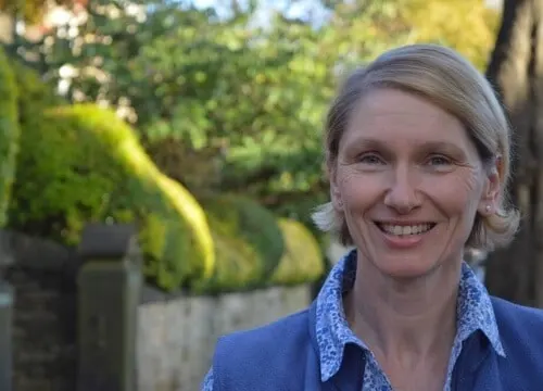 A photo showing Green Party election candidate Alison Teal smiling against a rural village background
