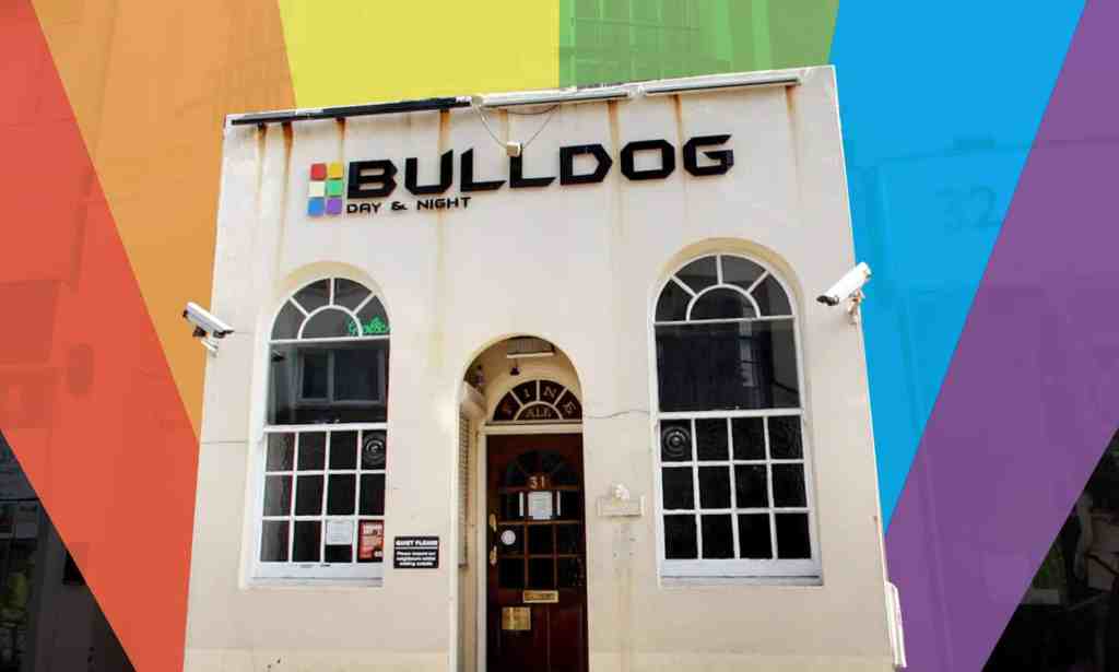 A small white building with Bulldog writte above the door. The picture has been cut out and placed on a rainbow background