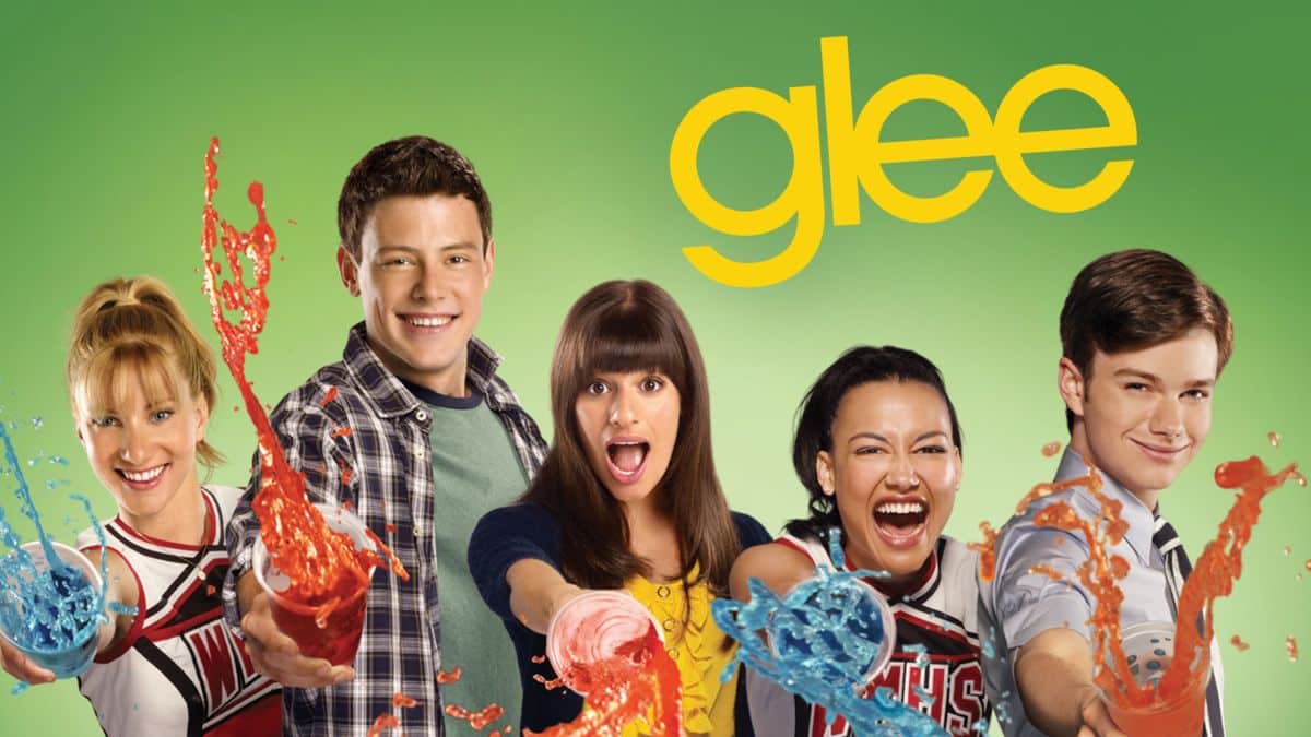 A promotional still of TV series Glee featuring all of the main cast superimposed against a green background with the Glee logo above them