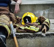 A firefighter sits on concrete steps