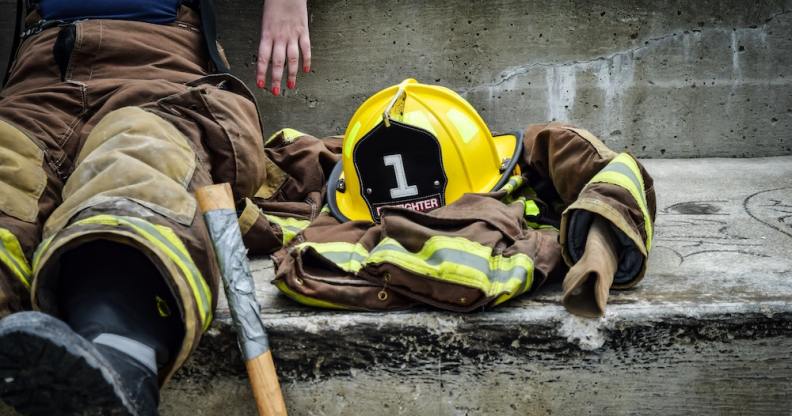 A firefighter sits on concrete steps
