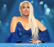 An image for Trans Awareness Week shows drag queen Jiggly Caliente wearing a blue dress standing in front of a blue background with spotlights