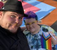 A photo of chef Dave Heide dressed in black and wearing a black hat with his arm round his child Ollie who's wearing a tie-dye t-shirt, yellow glasses and is holding a Pride flag