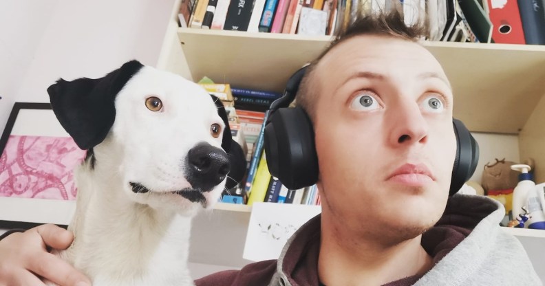 Matty Sheldrick wears headphones and poses with their dog Lola