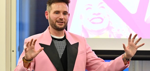 PinkNews' Chief Operating Officer Anthony James wears a pink blazer with black lapels as he speaks at the PPA Independent Publisher Conference and Awards on 25 November 2022 (PPA)