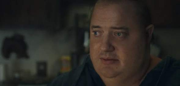 A still from the movie The Whale showing actor Brendan Fraser as obese character Charlie wearing a black shirt