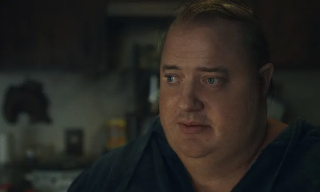 A still from the movie The Whale showing actor Brendan Fraser as obese character Charlie wearing a black shirt