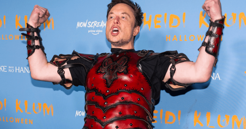 Elon Musk flexes while wearing a set of read armour during a Haloween christmas party.