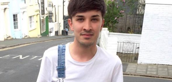 A photo of one of the Manchester Arena bombing victims, Martyn Hett, wearing a white t-shirt and dungerees with one strap, smiling outside a street corner.