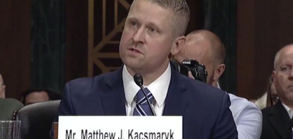 Federal district judge Matthew Kacsmaryk speaks before a judiciary committee wearing a blue suit, with an audience behind him.