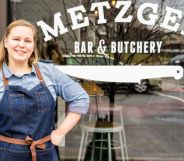 Metzger Bar and Butchery owner Brittanny Anderson stands outside her restaurant, wearing denim dungarees and a blue top.