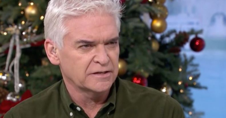 Phillip Schofield, who is wearing a green-brown shirt, talks to other people gathered for an episode of This Morning
