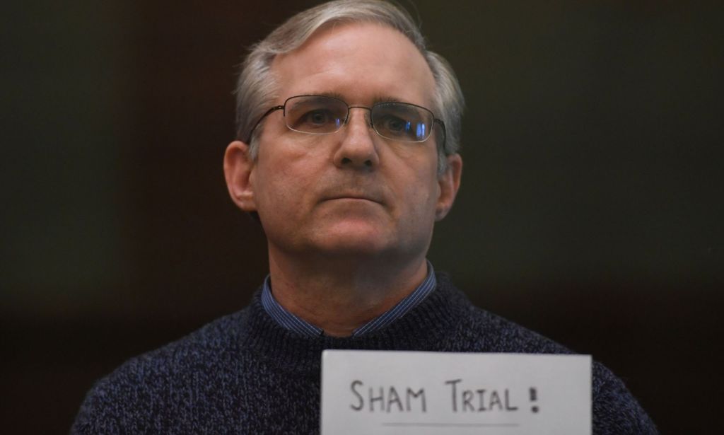 US marine Paul Whelan holds up a sign reading 'sham trial' while standing in the defendant's area during his trial in Russia