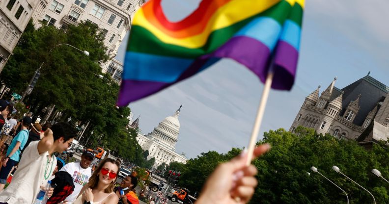 A LGBTQ+ pride flag is seen in front of the US capitol building