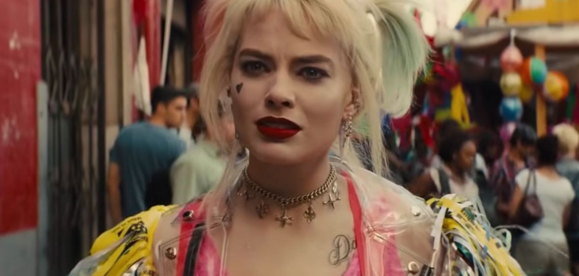A still from movie Birds of Prey showing actor Margot Robbie playing DC character Harley Quinn, who is styled wearing blonde pigtails and brightly coloured clothing
