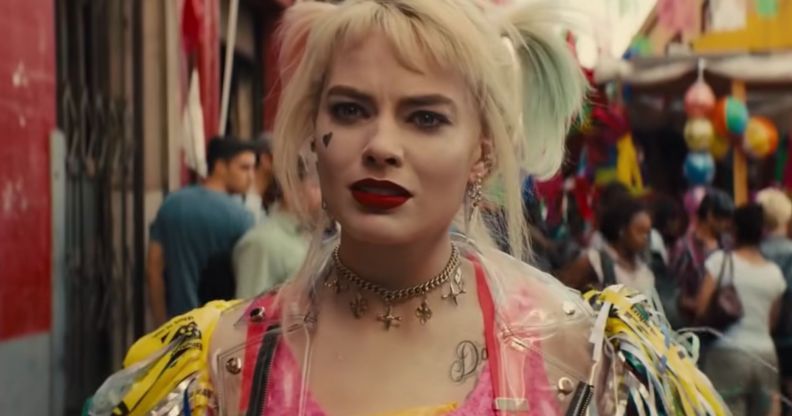 A still from movie Birds of Prey showing actor Margot Robbie playing DC character Harley Quinn, who is styled wearing blonde pigtails and brightly coloured clothing