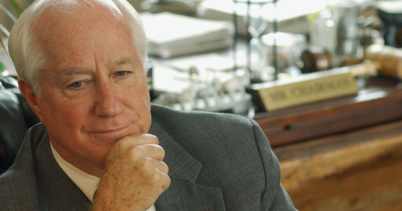 Jim Kolbe poses with his hand in front of his face as he sits down near a desk