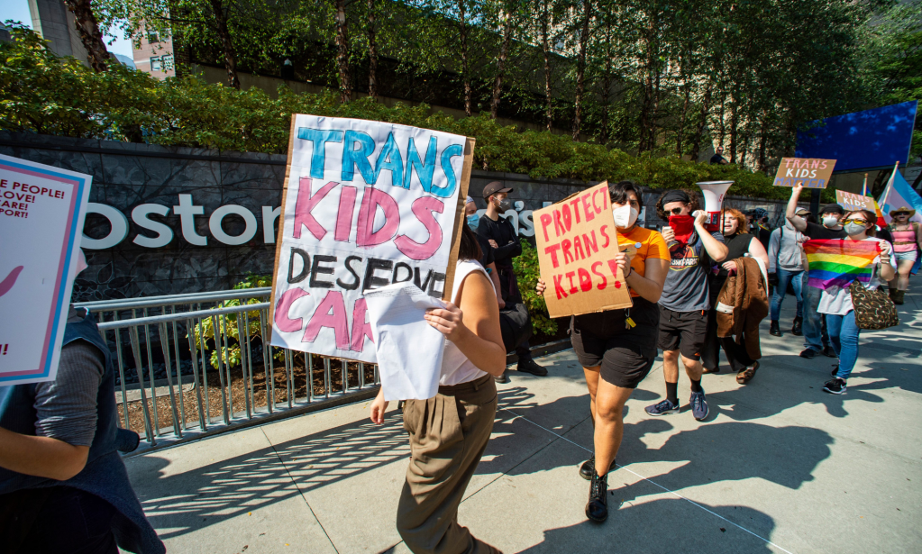 People hold up signs in support of the Boston Children's Hospital and the trans community after the hospital was targeted by right-wing groups over its trans healthcare programme