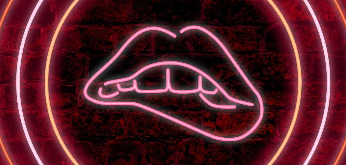 A neon sign of teeth biting lips