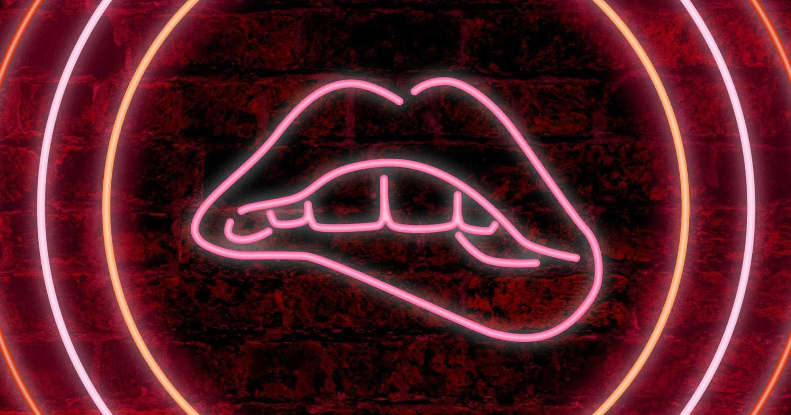 A neon sign of teeth biting lips