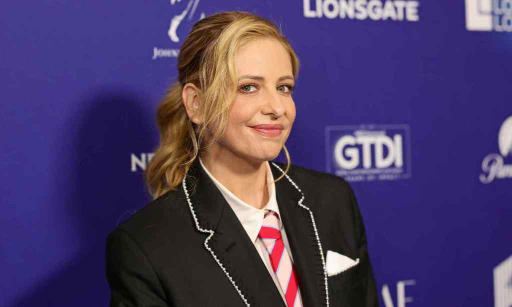 Headshot of actress Sarah Michelle Gella wearing a school-type blazer uniform outfit with red and white striped tie as she poses at the The Wrap's Power of Women Summit event in Los Angeles