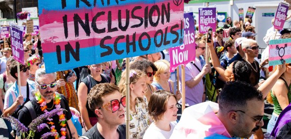 A photo from London Trans + Pride event shows protesters holding up a sign reading "trans inclusion in schools"