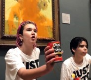 A photo of Just Stop Oil activists Anna Holland and Phoebe Plummer wearing T-shirts with the slogan "Just Stop Oil" kneel in front of Van Gogh's Sunflowers in London's National Gallery, which is covered in tomato soup