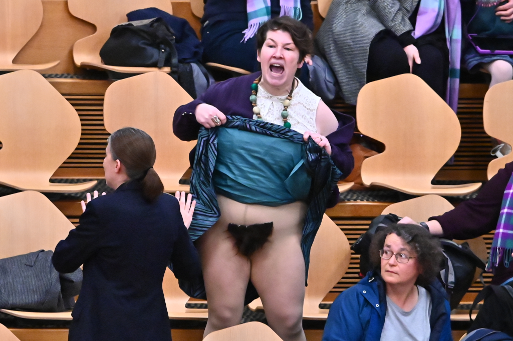 Protester lifts skirt to reveal pubic wig in Scottish parliament during Gender Recognition Reform vote