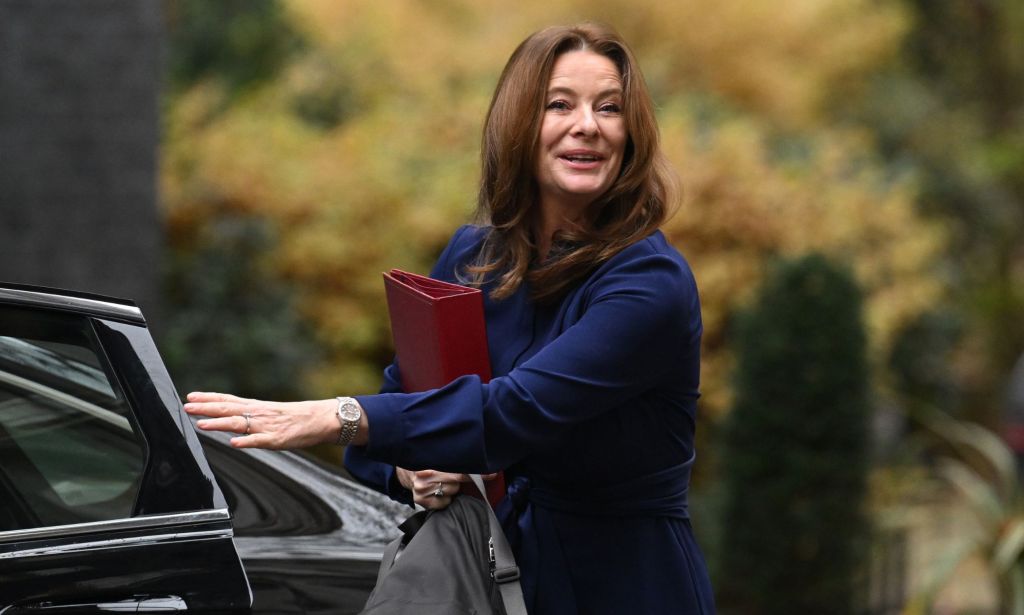 Gillian Keegan, wearing a nevy blue suit, exits a black car to walk towards Number 10 Downing Street. 