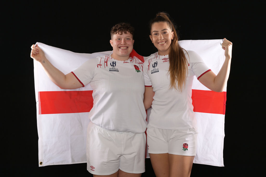 Hannah and Holly holding an England flag behind them