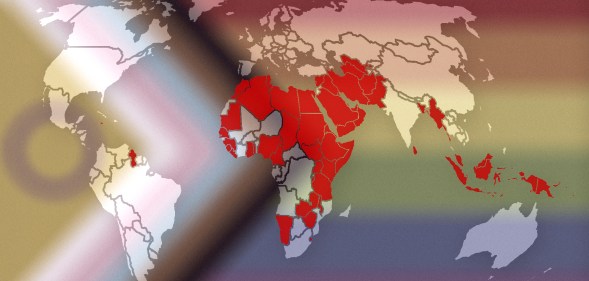 This image shows a map of the world, with countries and territories where LGBTQ+ people are criminalised are marked in red. The map is laid over the Progress Pride flag, which incorporates intersex identities, Black people and people of colour, and the entire LGBTQ+ community.
