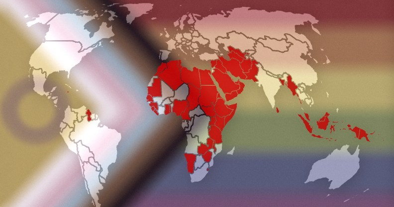 This image shows a map of the world, with countries and territories where LGBTQ+ people are criminalised are marked in red. The map is laid over the Progress Pride flag, which incorporates intersex identities, Black people and people of colour, and the entire LGBTQ+ community.