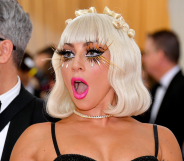 Lady Gaga wearing eyelash extensions, bright pink lipstick and revealing top attends the 2019 Met Gala