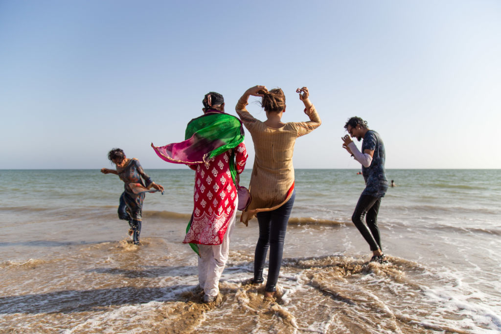Members of the transgender community play in the water during a picnic ahead of the Women's March at the Nomads Beach Resort on Hawksbay Beach on March 04, 2021 in Karachi, Pakistan.