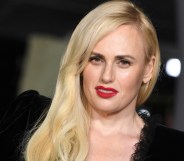 Rebel Wilson slightly tilted wearing red lipstick and a black dress, cropped to show her shoulder and head (Getty)