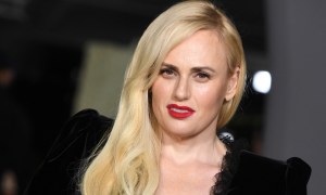 Rebel Wilson slightly tilted wearing red lipstick and a black dress, cropped to show her shoulder and head (Getty)