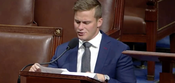 Dressed in a navy blue suit, white shirt and grey tie Madison Cawthorn gives his final address at the House of Representatives, sat a podium and talking into a microphone