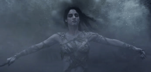 A still from The Mummy (2017) featuring the Mummy played by actress Sofia Boutella with her arms out and eyes closed while being covered in a mist
