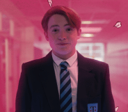 A still from Netflix's Heartstopper which shows Kit Connor as Nick Nelson wearing his school uniform