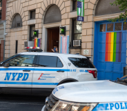 NYPD car in front of bar with rainbow flag