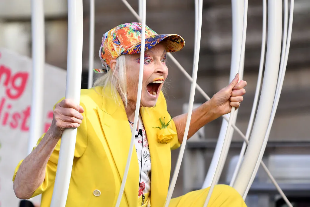 Vivienne Westwood in a yellow suit, behind bars