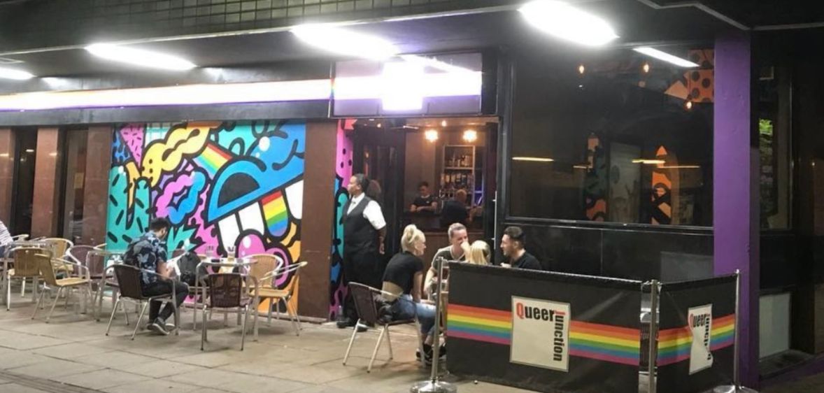 A photo of Sheffield gay club Queer Junction shows a group of people sat outside at one of its tables