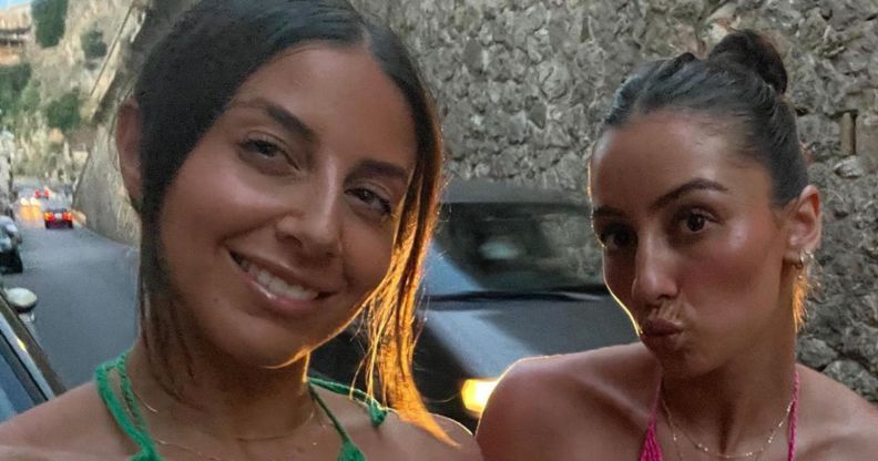 A photo shows two women, one is wearing a green bikini, and the other a pink bikini. The woman on the left is smilng while the other one is pouting